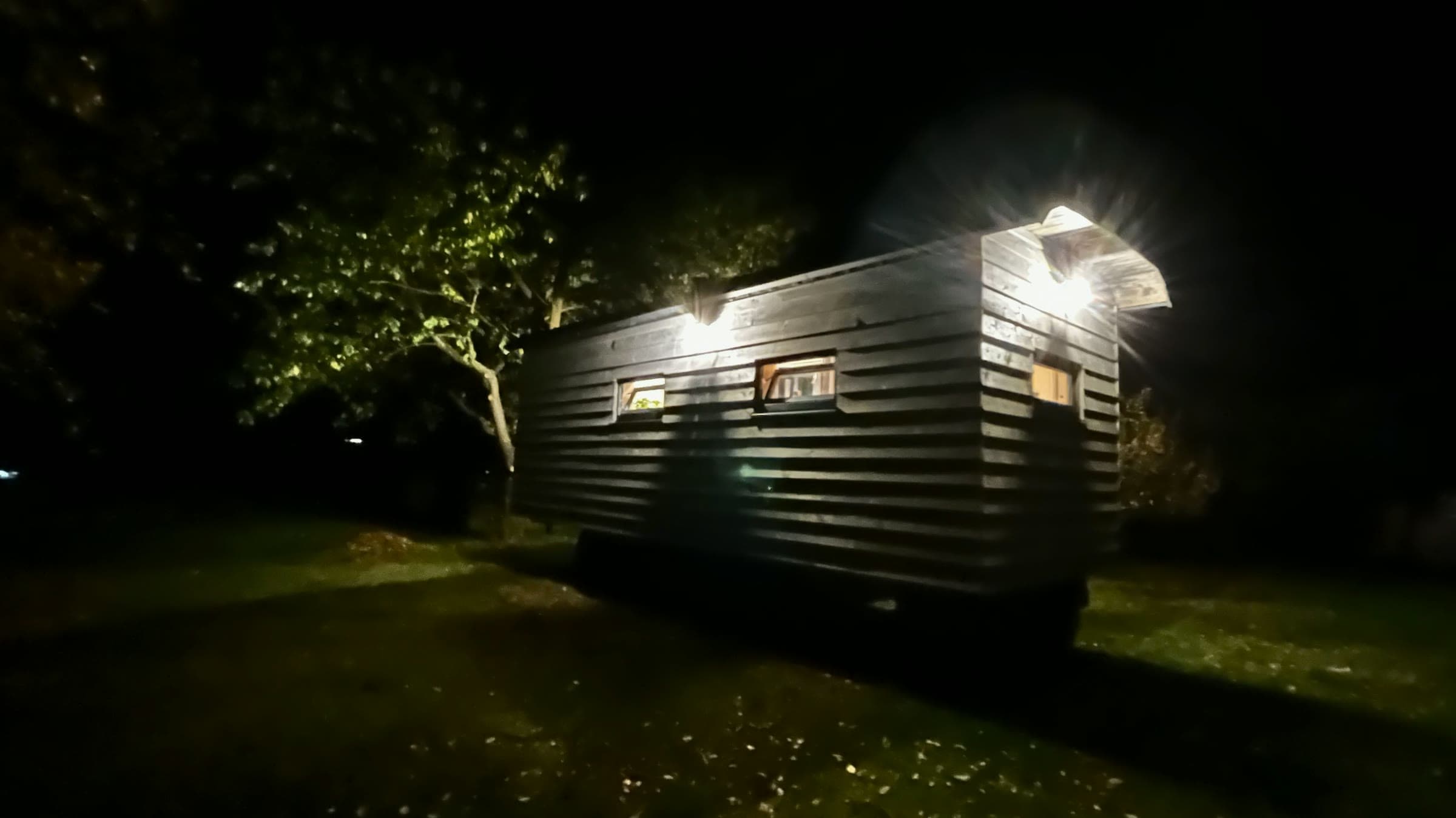 Bok maringotky v noci, světlo z oken a lamp